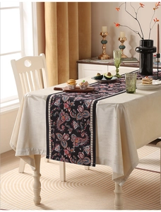 Dettaglio del runner da tavola vintage con motivo paisley su tovaglia in lino color crema