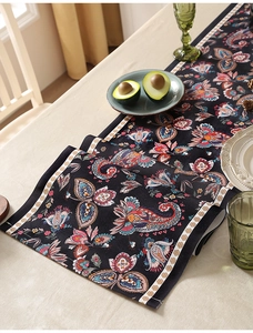 Dettaglio del runner da tavola boho con motivi paisley colorati e bordo geometrico