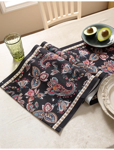 Dettaglio di runner da tavola con motivo paisley e bordo in pizzo color crema