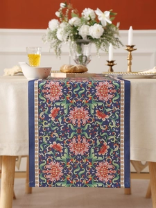 Detail of bohemian floral table runner with intricate oriental patterns in blue and red
