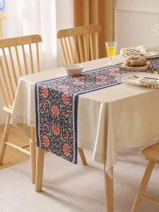 Detail of bohemian dark blue table runner with pink floral patterns and stitched edges