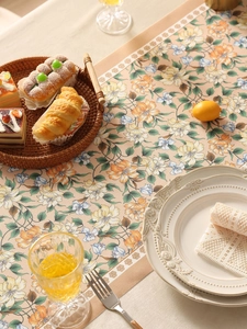 Dettaglio del runner da tavola in poliestere con motivi vintage di uccelli e fiori