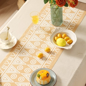 Runner da tavola giallo stile boho con motivi geometrici bianchi per decoro casa