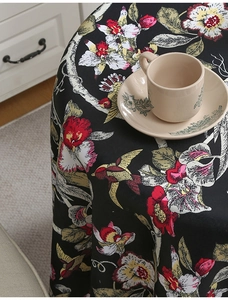 Detail der Vintage-Blumen-Tischdecke mit Kolibris auf hochwertigem Stoff