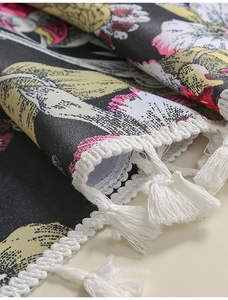Detail eines böhmischen Tischläufers mit Blumenmuster und weißen Webfransen
