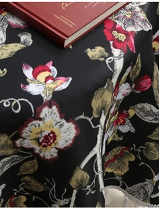 Detaillierte Nahaufnahme von Vintage-Blumenmuster und Stofftextur auf schwarzer Tischdecke