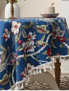 Detailaufnahme von Vintage-Vogelmuster und weißen Quasten am dunkelblauen Tischtuch