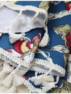 Detailaufnahme von dunkelblauem Blumenstoff mit Textur und weißen Fransen am Saum
