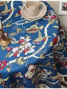 Detail einer luxuriösen Tischdecke in Marineblau mit Blumenmuster und weißen Quasten