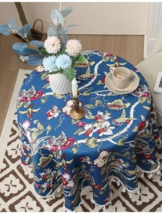 Detail der runden dunkelblauen Tischdecke mit Blumenmuster und eleganten weißen Fransen