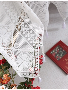 Macro detail of white lace valance with heart patterns and elegant tassel fringe