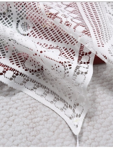 Close-up of white lace window valance with floral embroidery and hollow-out texture
