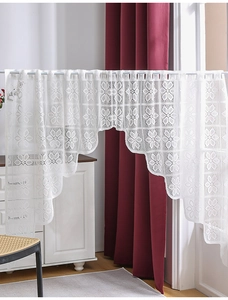Detail of white floral lace valance featuring scalloped tiered edges and sunflower patterns