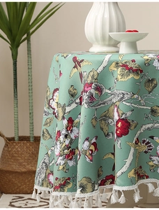 Detail der runden mintgrünen Tischdecke mit Blumen-, Vogelmustern und weißen Fransen