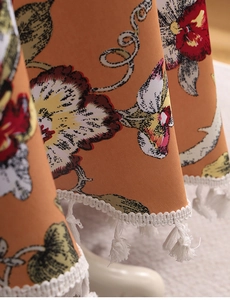 Nahaufnahme der Vintage-Blumendecke mit gewebter Spitze und weißen Quasten-Verzierungen