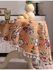 Detailansicht der floralen Tischdecke mit Vögeln und weißen Fransen auf rundem Tisch
