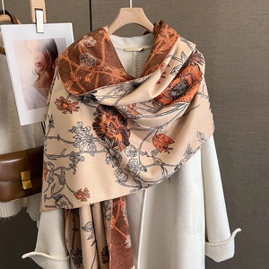 Detail of vintage floral print pashmina shawl draped over a classic white winter coat