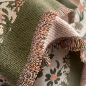 Detailed view of winter thick scarf featuring olive green floral patterns and fringe tassels