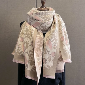 Detailed view of winter scarf fabric featuring floral jacquard and delicate fringe trim