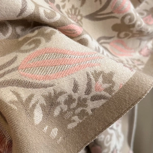 Macro view of woven winter scarf showing high-quality floral jacquard and fine fabric texture