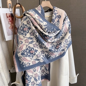 Detail of vintage floral pattern scarf with pink fringe on white coat winter styling