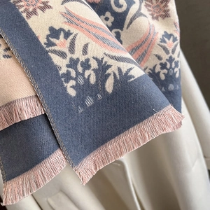 Detail of ethnic floral jacquard pattern and tassel fringe on winter thick scarf