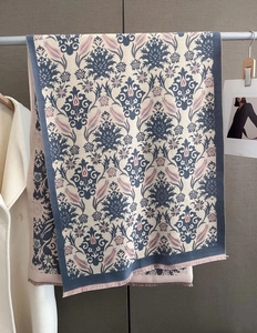 Detail of damask pattern jacquard scarf with fine fringe on a silver hanger