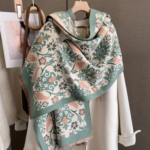 Detail of floral knit scarf with fringe edge paired with wool coat for winter style