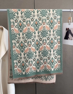 Detail of floral jacquard winter scarf with elegant brown fringe and thick texture