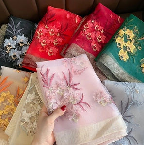 Close-up of exquisite floral embroidery and metallic edges on lightweight silk wool scarves