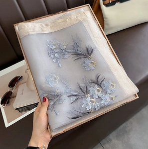 Detailed embroidery on grey silk wool shawl featuring delicate blue floral patterns