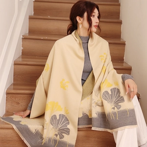 Close-up of elegant ginkgo leaf pattern on thick beige winter scarf with tassels