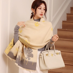 Detail view of thick beige scarf with yellow floral patterns and soft short fringe