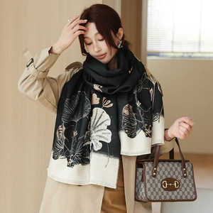 Detail of warm winter scarf with lotus floral pattern and elegant fringe tassels