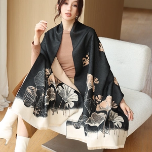 Detail of soft winter scarf with ginkgo leaf pattern and delicate tassel edges