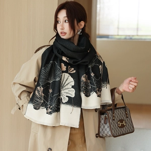 Close-up of thick winter scarf featuring artistic lotus patterns and fine fringe details