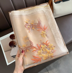 Detailed embroidery on champagne silk wool scarf presented in a luxury gift box