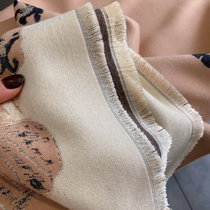 Macro view of beige ginkgo leaf pattern scarf with detailed fringe and woven texture