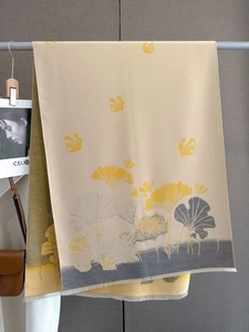 Detail of warm winter scarf with ginkgo leaf pattern and delicate fringe tassels