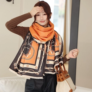 Détail de l'écharpe orange au toucher cachemire avec motifs de chaînes et d'étriers