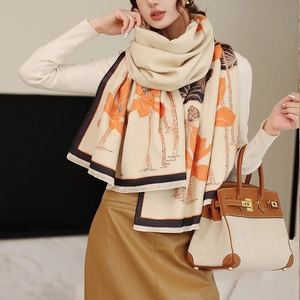 Detail of cream scarf with orange lotus print and fringe edges worn by a model