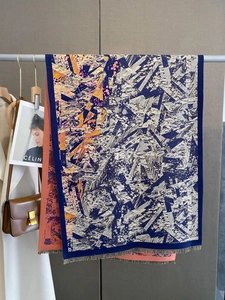 Detail of geometric rhombus pattern cashmere-style scarf with fringe and soft sheen finish