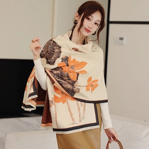 Close-up of beige lotus print scarf with orange flowers and tassel edges detail
