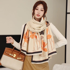 Detail of warm beige pashmina scarf with orange tropical print and fringe edges