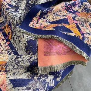 Close-up of geometric pattern jacquard shawl with thick cashmere feel and fringe details