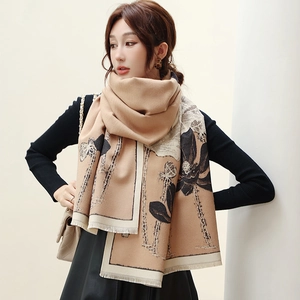 Detailed close-up of cashmere-like scarf with black lotus prints and soft fringe edges