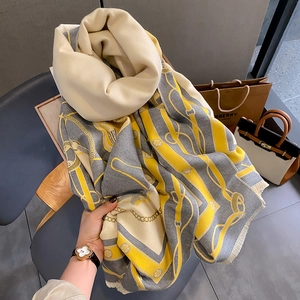 Gros plan d'un châle en cachemire jaune et gris avec motifs de harnais et de franges