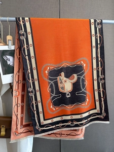 Détail d'un châle en cachemire orange avec des motifs luxueux de selle et de chaîne