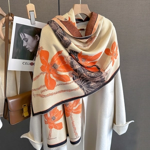 Detail of cashmere-like floral scarf with lotus patterns on a classic white coat