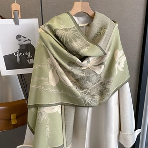 Detail of light green cashmere shawl with white lotus print over a white wool coat